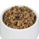 Eine weiße Haustierfutterschüssel gefüllt mit einer stückigen, feuchten Mischung aus Fleisch und Getreide, geeignet für Hunde oder Katzen.