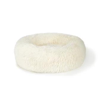 Pluizig wit hondenbed met een ronde vorm, ontworpen voor comfort en ontspanning.