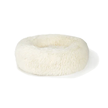 Pluizig wit hondenbed met een ronde vorm, ontworpen voor comfort en ontspanning.