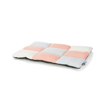 Ein weiches, rechteckiges Haustierbett mit einem Patchwork-Design in Pastellrosa, Grau und Weiß, mit einem kleinen Herz, das in eine Ecke gestickt ist.