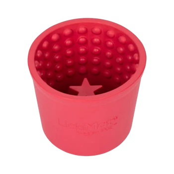 Rotes Silikonhaustierspielzeug mit strukturiertem Inneren und einer sternförmigen Basis, beschriftet mit "LickiMat® Yoggie Pot™".
