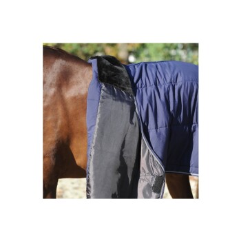 Eine Nahaufnahme eines braunen Pferdes, das eine marineblaue gepolsterte Decke trägt, die den weichen schwarzen Kragen und das Innenfutter zeigt.