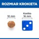 Obraz porównujący rozmiar krokieta karmy dla zwierząt (10 mm) obok niebieskiej kostki (16 mm), z tekstem "ROZMIAR KROKIETA" i "Kostka."