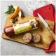 Futterrolle auf Brett mit Aufschrift 'FLEISCHESLUST ZIEGE mit Lamm', zwei Scheiben, Beeren, Messer und rotes Tuch