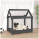 Ein Mops liegt auf einem grauen Haustierbett in einem Holzrahmen für Hundehäuser, in einem hellen Raum mit einem Fußball in der Nähe.
