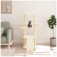 Ein gemütliches Wohnzimmer mit einem beigen Katzenbaum, auf dem eine getigerte Katze sitzt, einem grünen Sofa und einer Topfpflanze.