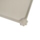 Eine hellbeige Haustierfuttermatte mit einem Pfotenabdruckdesign in einer Ecke, entworfen, um Verschüttungen aufzufangen und die Futterbereiche sauber zu halten.