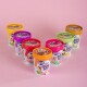 Bunte Becher von Swoof Mix Hundeeis, die in einem Halbkreis auf einem rosa Hintergrund angeordnet sind, mit verschiedenen Geschmacksrichtungen und einem Hundebild auf jedem Behälter.