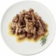 Een bord met fijngehakt, vochtig vlees in een hartige saus, gegarneerd met een takje dille.