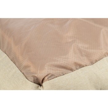 Nahaufnahme eines Haustierbettes mit einer glatten, hellbraunen Oberseite mit gepunkteter Textur und einem beigen Stoffrand.