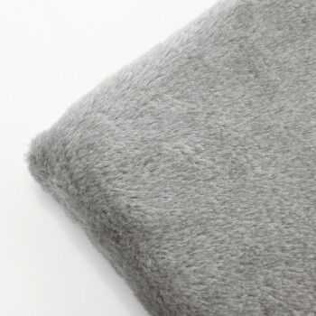 Eine weiche, graue Haustierdecke mit flauschiger Textur, teilweise gefaltet, vor einem weißen Hintergrund.