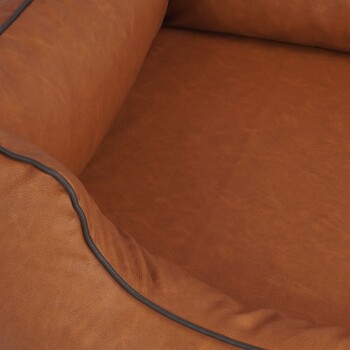 Eine Nahaufnahme eines gemütlichen, braunen Haustierbettes mit einer weichen, strukturierten Oberfläche und einem kontrastierenden schwarzen Rand entlang der Kante.