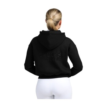 Eine Frau mit einem Pferdeschwanz trägt einen schwarzen Hoodie mit 'SPOOKS EQUESTRIAN' auf dem Rücken, kombiniert mit weißen Leggings.