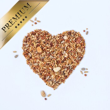 Ein herzförmiger Haufen verschiedener Vogelsamen auf weißem Hintergrund, gekrönt mit einem goldenen "PREMIUM"-Banner.