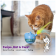 Eine verspielte orange Katze interagiert mit einem blauen Spielzeugspender auf einem Holzboden, mit dem Text: "Wischen, Schlagen & Schlagen. Lass das Spielzeug – und die Leckerlis – fliegen."